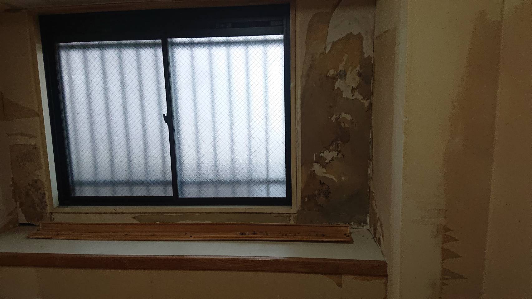 和室(壁紙を剥がし、下地のシミが見える窓際)