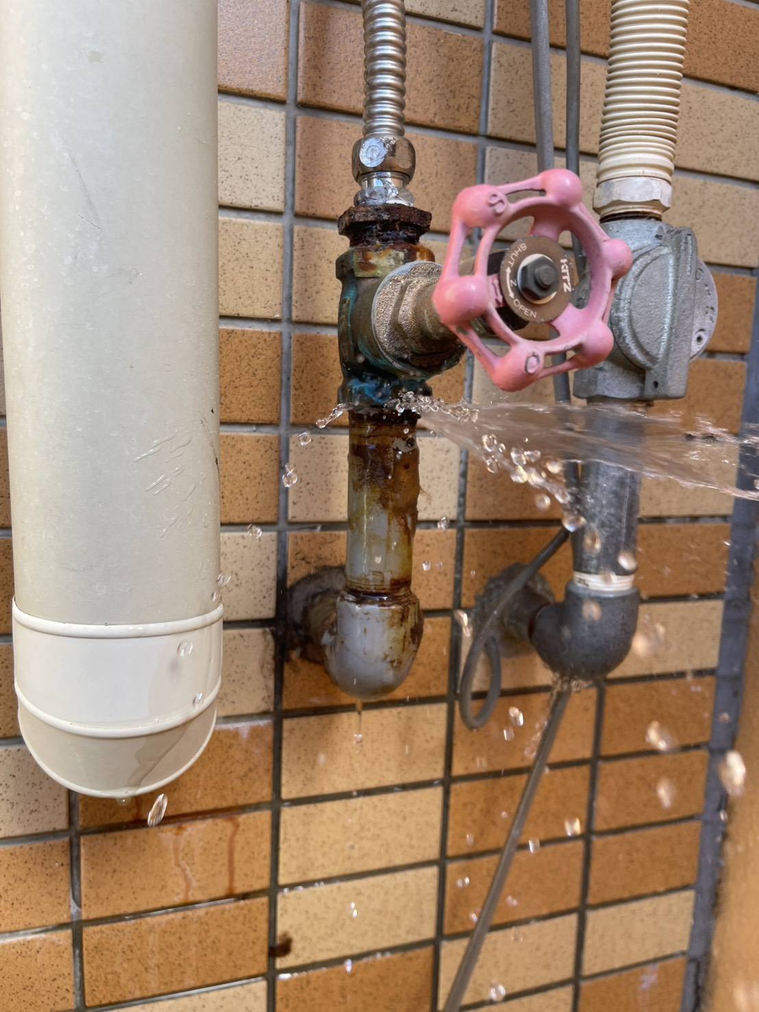 錆びたバルブから水が激しく噴出している様子