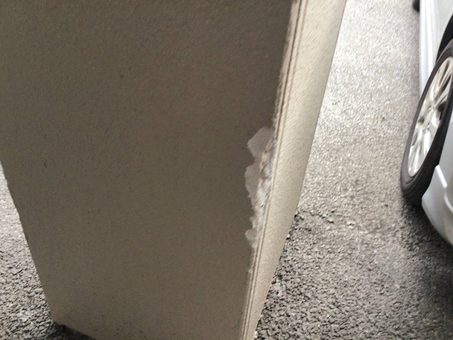 車両接触により破損した駐車場の外壁